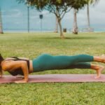 Woman in the open, performing a yoga plank pose.