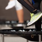 Photo of a person's legs and feet on a rebounder or mini trampoline.