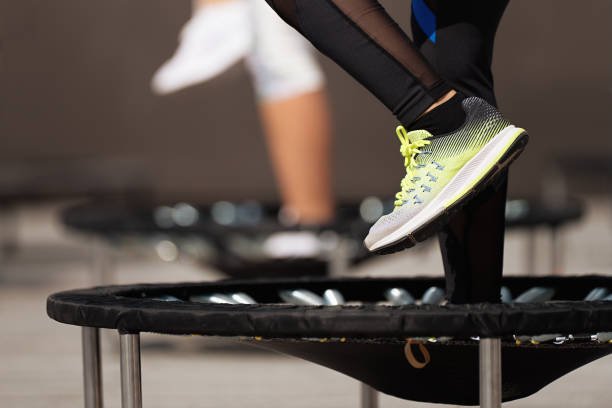 Photo of a person's legs and feet on a rebounder or mini trampoline.