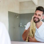 Photo of a handsome young man drying off with a towel in the bathroom