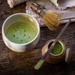 Closeup photo of Matcha tea preparations and a cup of Matcha tea